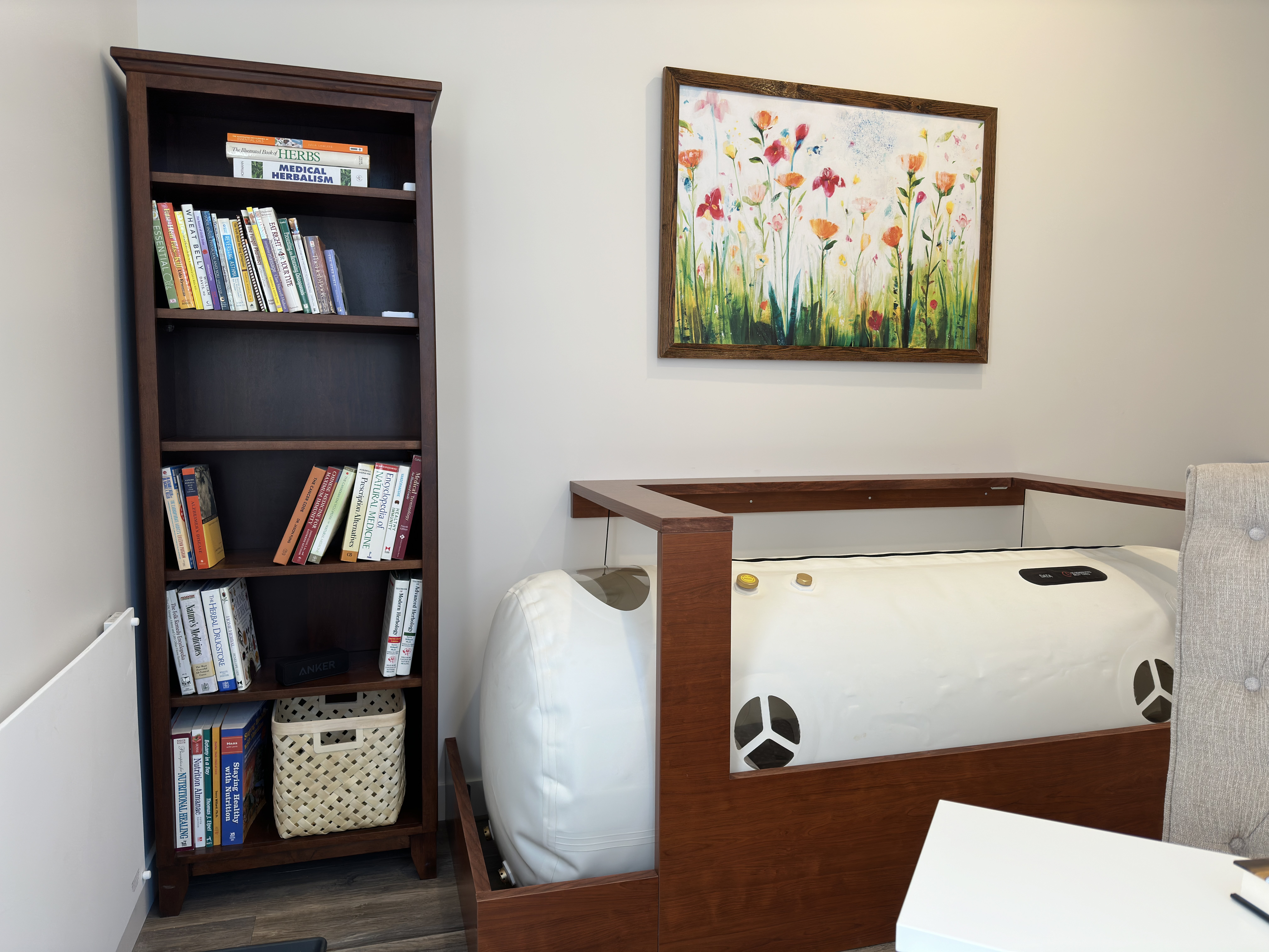 The wood-framed soft-shell chamber beneath the colourful floral painting.