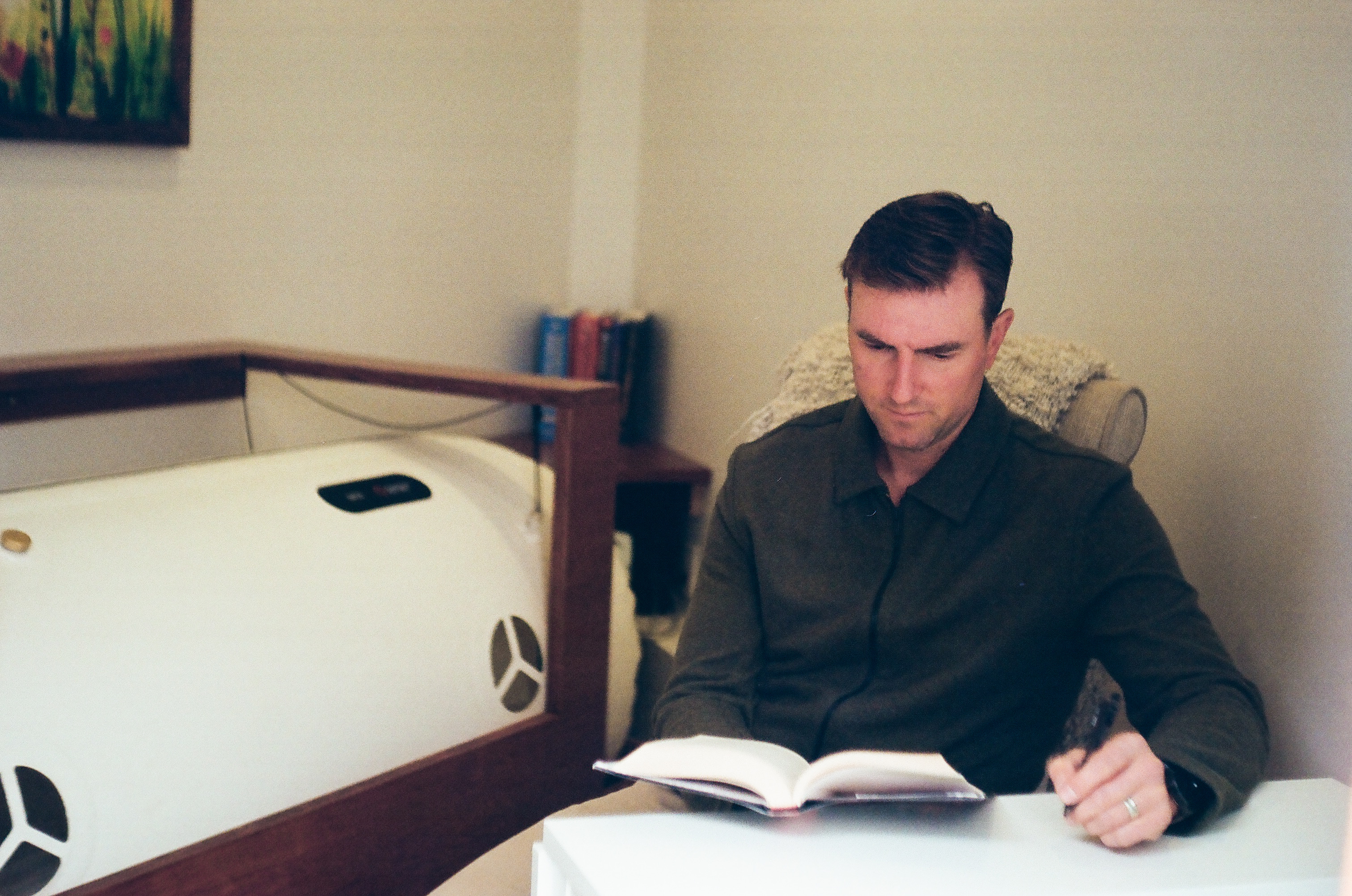 A guest reads quietly in the reading chair beside the soft-shell chamber.